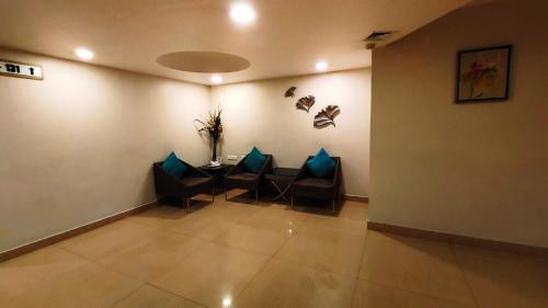 a room with two chairs and a table with blue pillows at Best Western Ashoka in Hyderabad