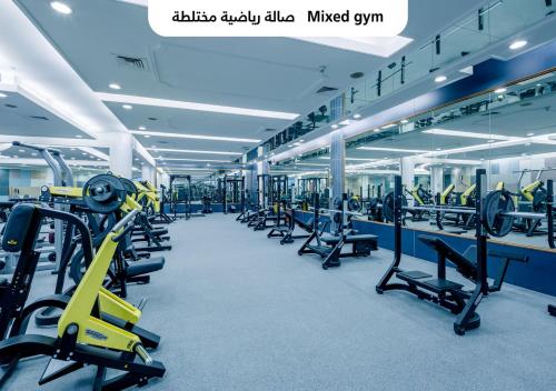a gym with rows of treadmills and machines at Officers Club & Hotel in Abu Dhabi