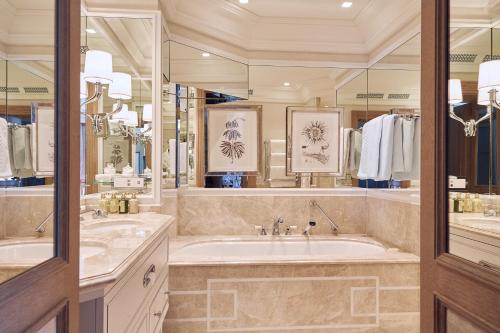 a large bathroom with two sinks and a tub at Badrutt's Palace Hotel St Moritz in St. Moritz