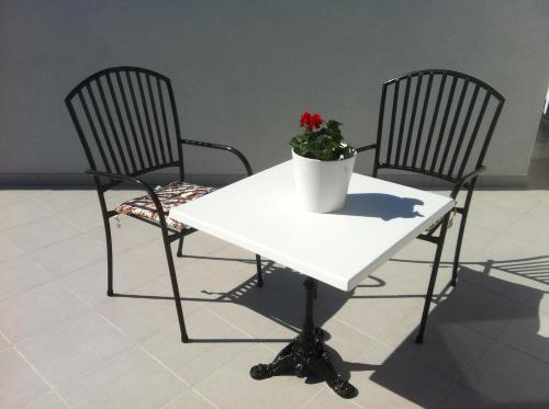 two chairs and a white table with a potted plant on it at Apartment-rooms Preka in Rab