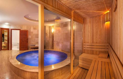 a jacuzzi tub in a wooden bathroom with a bench at Last Vita in Istanbul