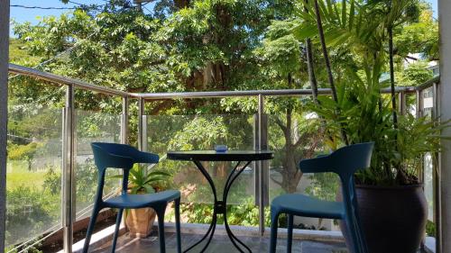 a patio with two chairs and a table in front of a window at View Mountain B&B in Checheng