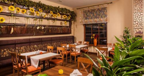 ニサにあるConferoのテーブルと椅子、壁に花を飾ったレストラン