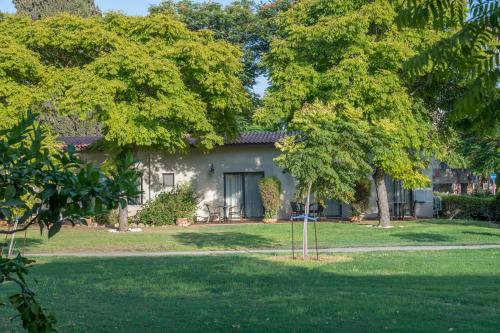 a house with a yard with trees in front of it at Degania Bet Kibbutz Country Lodging in Kinneret