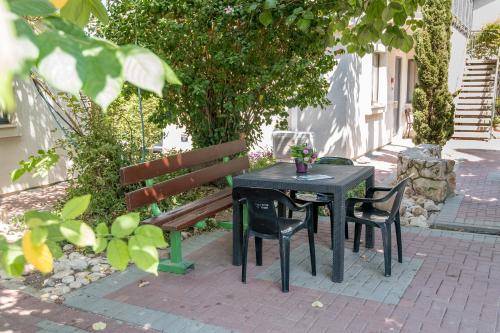 a table and a bench with a table and chairs at Degania Bet Kibbutz Country Lodging in Kinneret