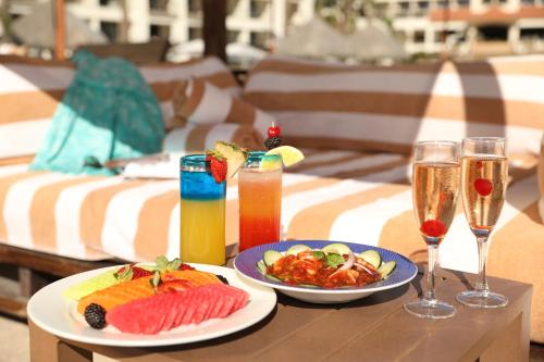 a table with two plates of food and drinks at Hyatt Ziva Los Cabos - All Inclusive in San José del Cabo