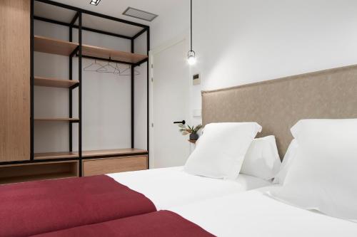 a bedroom with a white bed with a red blanket at Jai Alai 54 by FeelFree Rentals in Donostia-San Sebastián