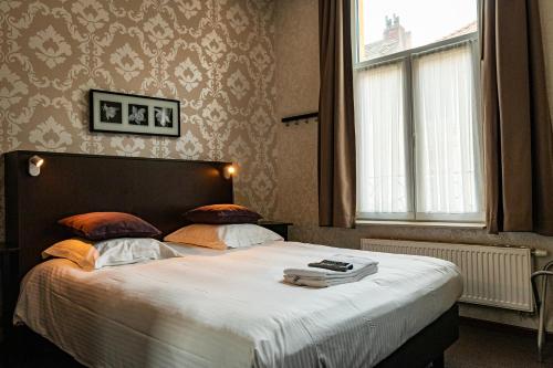 a bedroom with a large bed with a large window at Vakantielogies Cathedral in Ghent