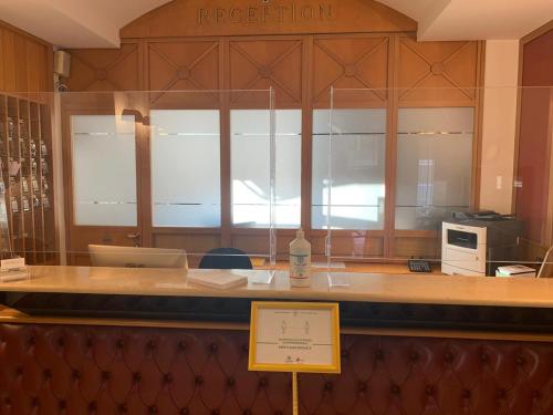 a restaurant with a counter with a bottle of wine at Hotel Continental in Turin