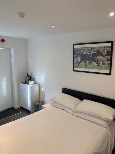 a bedroom with a bed and a picture on the wall at The Olive in Market Rasen
