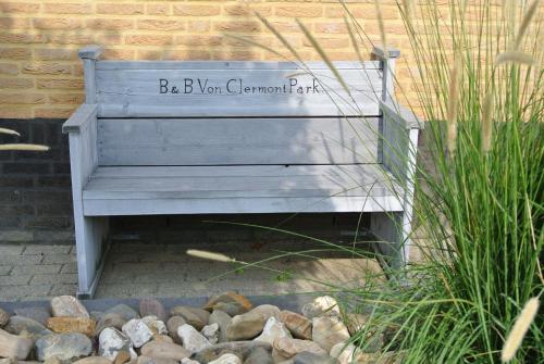 a wooden bench sitting next to a pile of rocks at B&B Von Clermont Park in Vaals