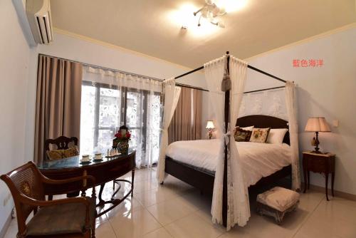潮州鎮的住宿－亨泰民宿2-8人包棟，一间卧室配有一张天蓬床、一张桌子和一张书桌。
