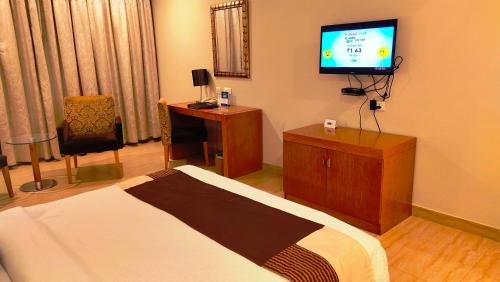a hotel room with a bed and a flat screen tv at Best Western Ashoka in Hyderabad