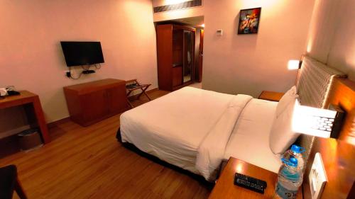 a hotel room with a bed and a television at Best Western Ashoka in Hyderabad