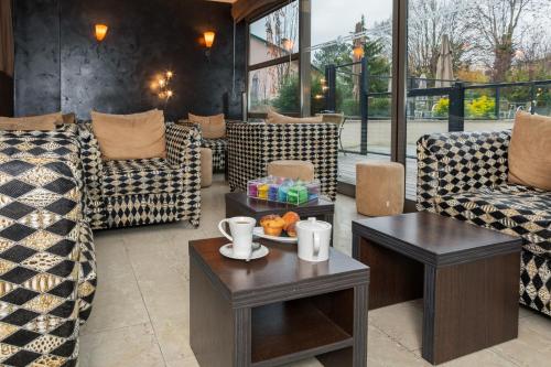 a lobby with couches and a table with fruit on it at Résidence la Réserve Genève Ferney Voltaire in Ferney-Voltaire