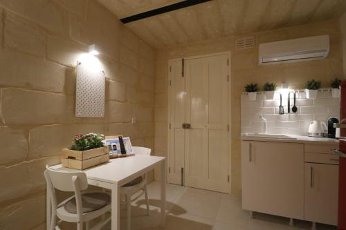 a small kitchen with a white table and a counter at Valletta Central Suites in Valletta
