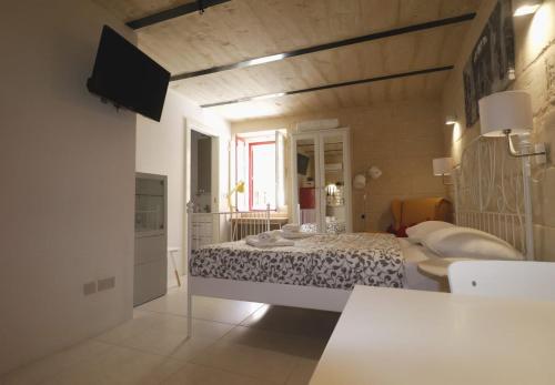 a white bedroom with a bed and a window at Valletta Central Suites in Valletta
