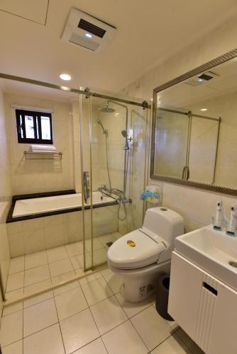 a bathroom with a shower and a toilet and a sink at 亨泰民宿2-8人包棟 in Chaozhou