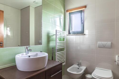 a bathroom with a sink and a toilet at Apartamento 7 Mares com Suite in Sagres