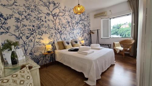 a bedroom with a bed with a blue and white wallpaper at Carmen de Alaïa By Florentia Homes in Granada