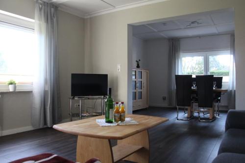 a living room with a table and a tv at Haus Sperling in Bad Zwischenahn