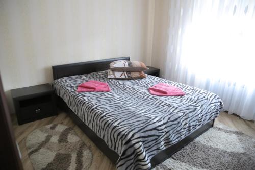 a bed with two pink pillows on it in a bedroom at ЗАТИШОК in Sinyak