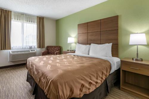 a hotel room with a large bed and a chair at Quality Inn in Creston