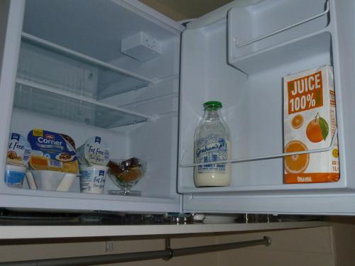 an open refrigerator with a bottle of milk and juice at Macs Rooms in Kilmuir