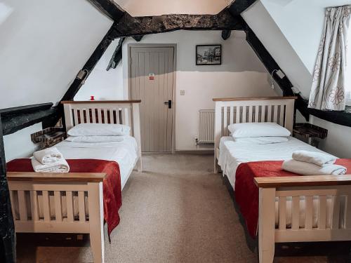 a attic bedroom with two beds in a attic at The Blenheim Buttery in Woodstock