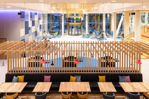 a view of a restaurant with wooden tables and benches at Holiday Inn Express Amsterdam - North Riverside, an IHG Hotel in Amsterdam