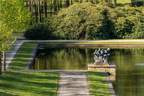 a garden with a statue in the middle of a pond at Parkhotel Bremen – ein Mitglied der Hommage Luxury Hotels Collection in Bremen