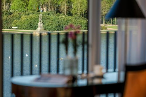 a balcony with a table and a view of the water at Parkhotel Bremen – ein Mitglied der Hommage Luxury Hotels Collection in Bremen
