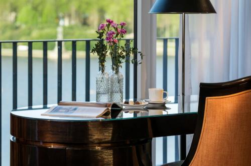 a table with a vase of flowers on a balcony at Parkhotel Bremen – ein Mitglied der Hommage Luxury Hotels Collection in Bremen