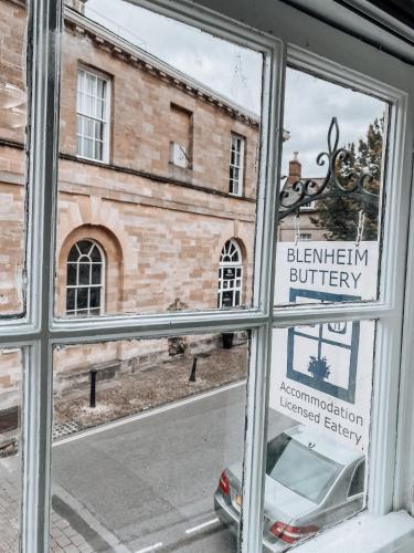 a window of a building with a reflection of a car in it at The Blenheim Buttery in Woodstock