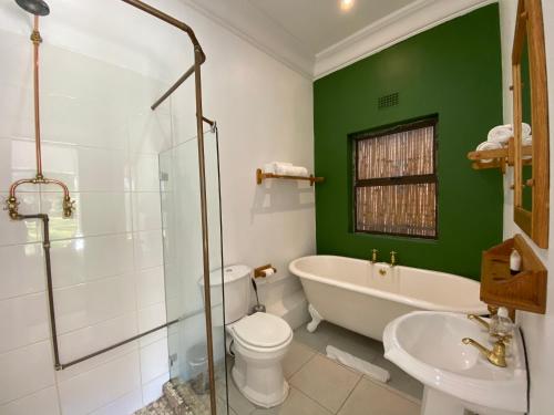 a bathroom with a tub and a toilet and a sink at The Welgemoed Guest House in Bellville