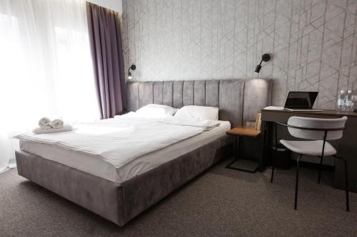 a bedroom with a bed and a desk with a laptop at Kulikovskiy hotel in Kharkiv