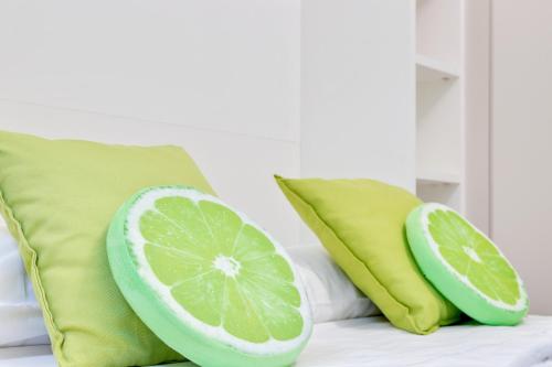 dos almohadas de lima y un corte de limón a la mitad en una cama en Modernissimo Loft in Porta Romana, a 200m dalla Bocconi, en Milán