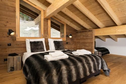 une chambre avec un grand lit avec des serviettes dessus dans l'établissement Le Mont Royal - Apt B401 - BO Immobilier, à Châtel