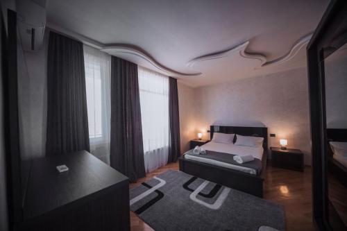 a bedroom with a bed and a large window at Makos Guest House in Kutaisi