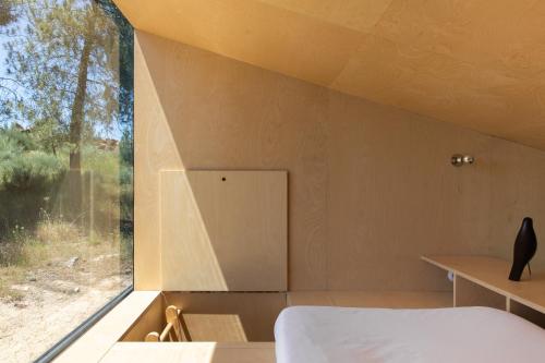 Dormitorio con ventana, cama y escritorio en CASA NO CASTANHEIRO, en Meda