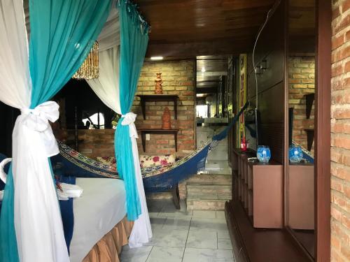 a room with a bed with a hammock in it at Pousada Alto Astral in Olinda