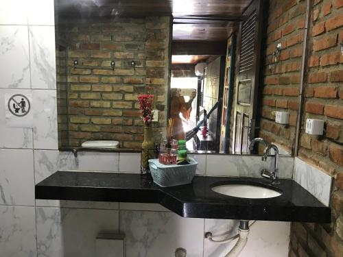 a bathroom with a sink and a mirror at Pousada Alto Astral in Olinda