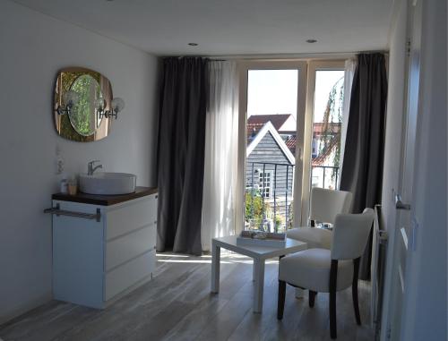 a bathroom with a sink and a table and a window at t Laege Uus in Burgh Haamstede