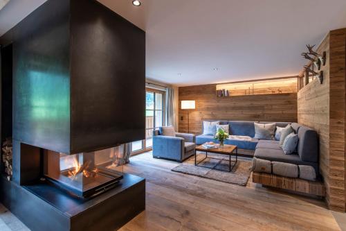 a living room with a couch and a fireplace at Brunnenhof Luxury Apartments in Lech am Arlberg
