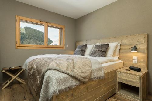 une chambre avec un grand lit et une fenêtre dans l'établissement Le Mont Royal - Apt B103 - BO Immobilier - Châtel, à Châtel