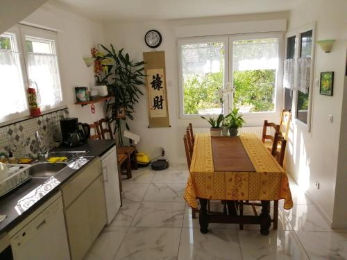 a kitchen with a table with a yellow table cloth at Villa Sunshine in Bagneux