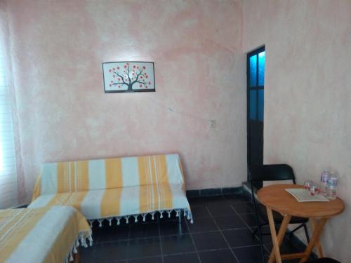 a room with a bed and a table and a window at Hospedaje Casa Cortés - Recamaras de Descanso, Tepoztlán Mor - NO CONTAMOS CON ESTACIONAMIENTO in Tepoztlán