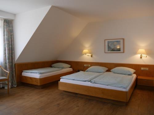 two beds in a room with a attic at Landgasthof Adler in Künzelsau