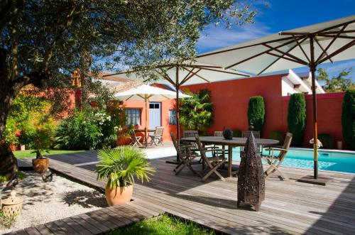 a wooden deck with a table and umbrella at La Ferrade Chambres d'Hôtes B&B in Bègles