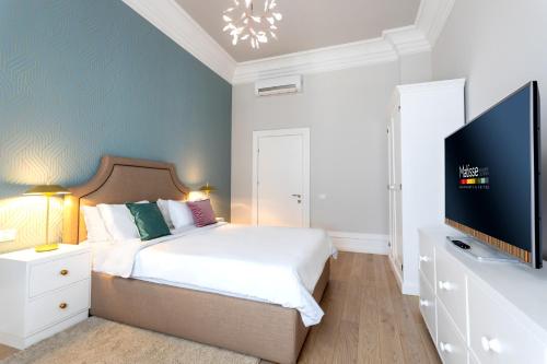 a bedroom with a bed and a flat screen tv at Matisse Bucharest Old Town in Bucharest